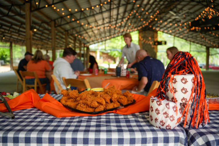 A family shares a tailgate at the Crooked Oaks pavilion.