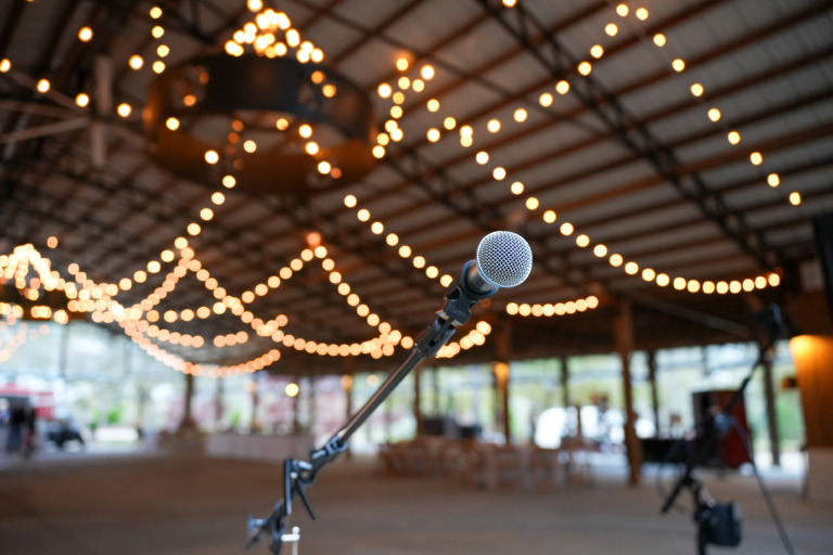 A microphone with the background blurred including an event pavilion.