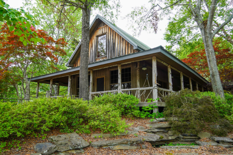 The Crooked Oaks Lake House among a green landscape.