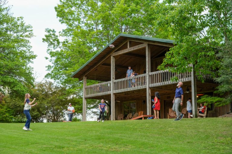 family playing yard games in front of a lodge