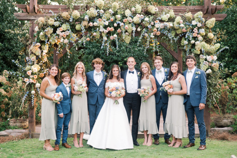 bride and groom with family at wedding pergola