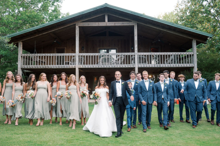 wedding party gather in front of lodge