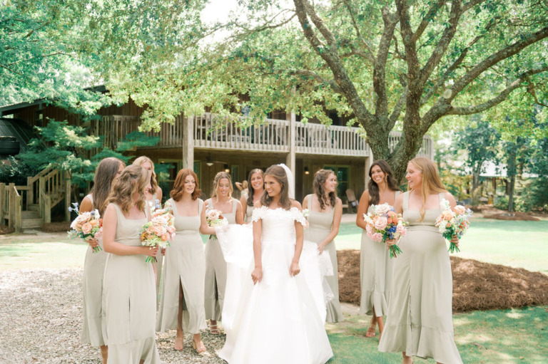 bride and bridesmaids under oak tree in front of lodge