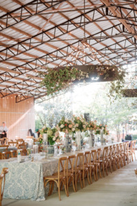 chandelier hovers over bridal table outfitted with lush table settings